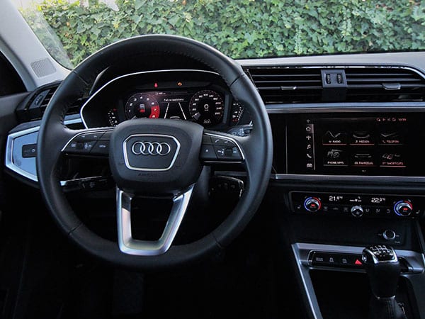 Innenraum des Audi Q3 Sportback: Lenkrad mit den vier Ringen, digitales Kombiinstrument, Touchscreen und Schalthebel in der Mittelkonsole